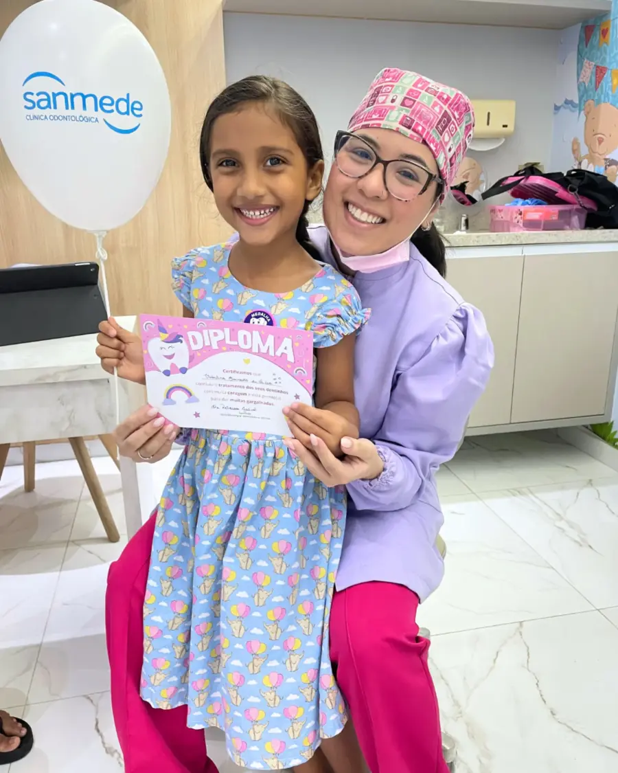 Paciente infantil recebendo diploma na clínica odontológica em Manaus Sanmede